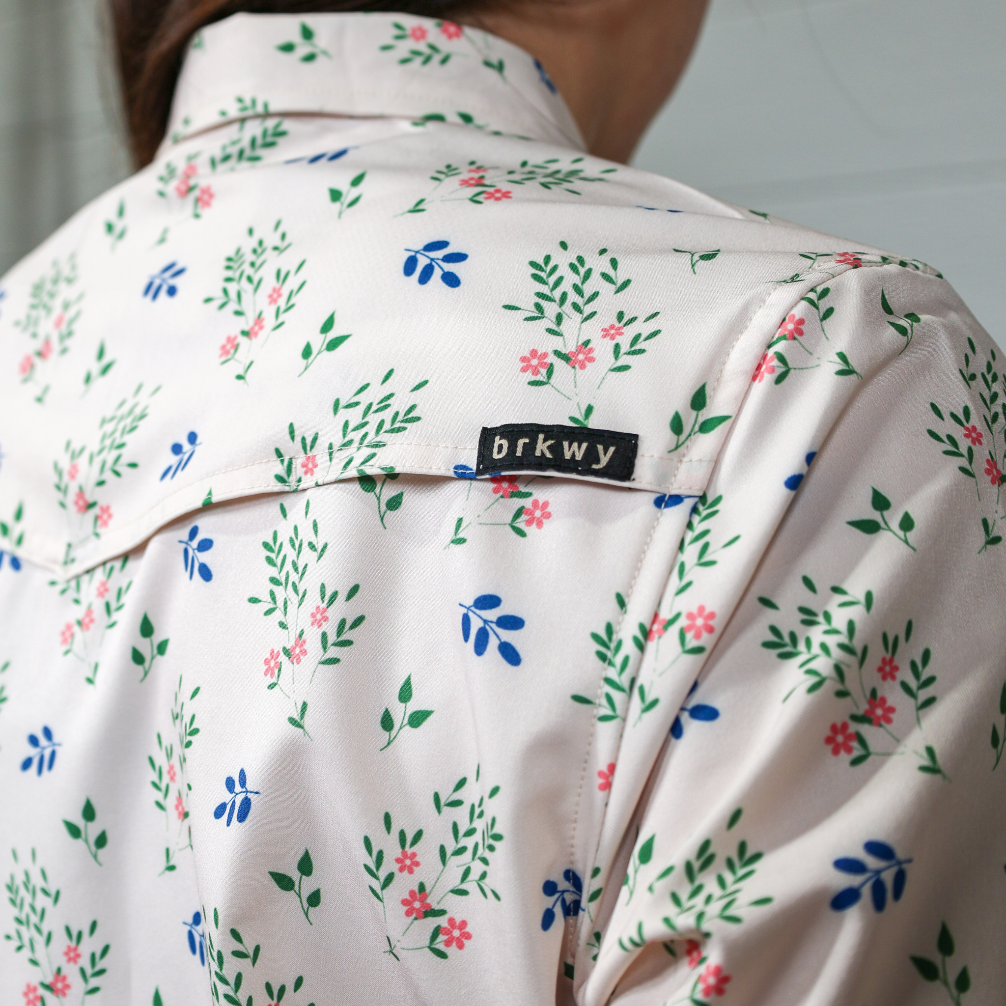 Floral-patterned shirt with 'brkwy' label on a plain white background. back facing.