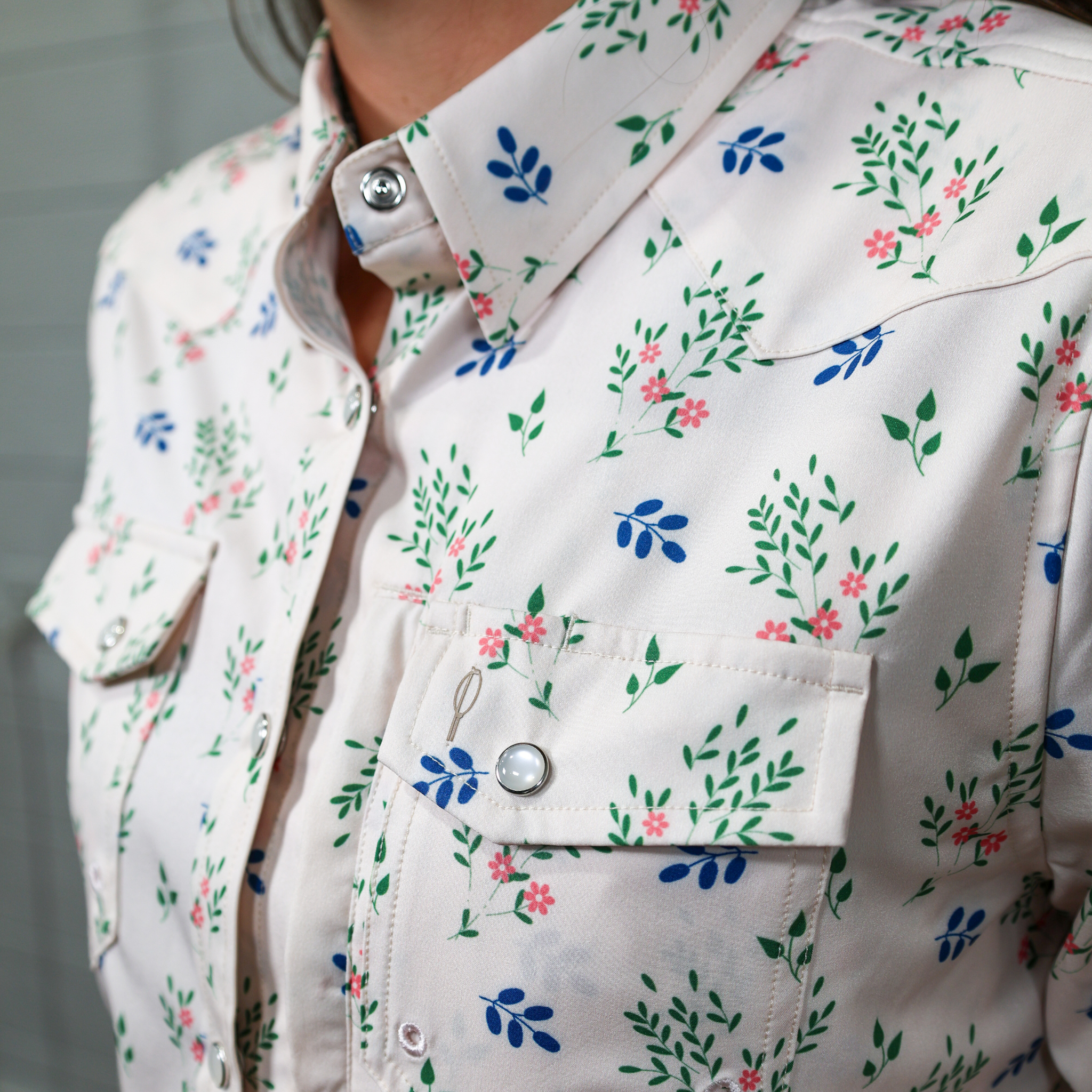 Close-up of a floral-patterned button down with a white background