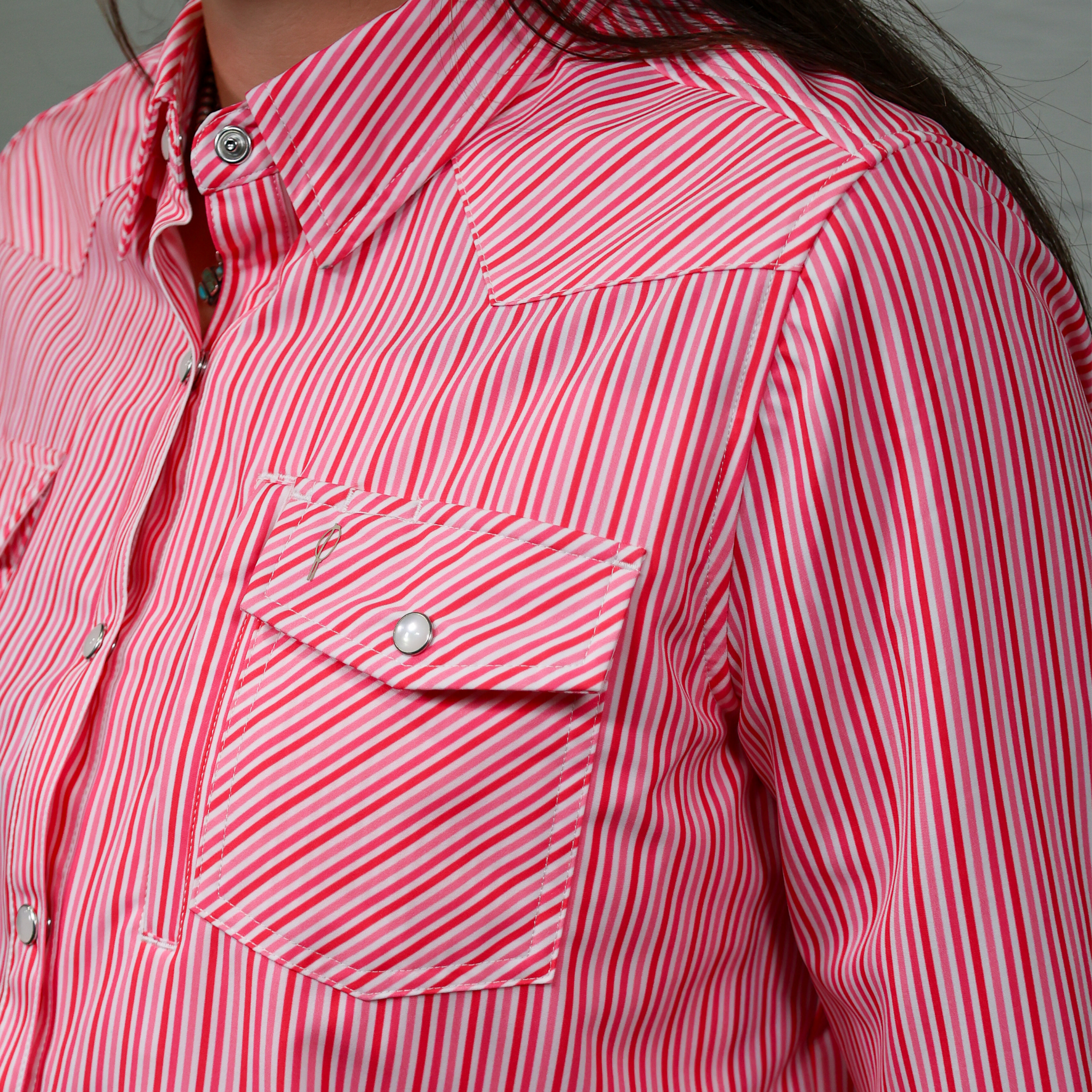 Close-up of a pink and white striped shirt with a pocket.