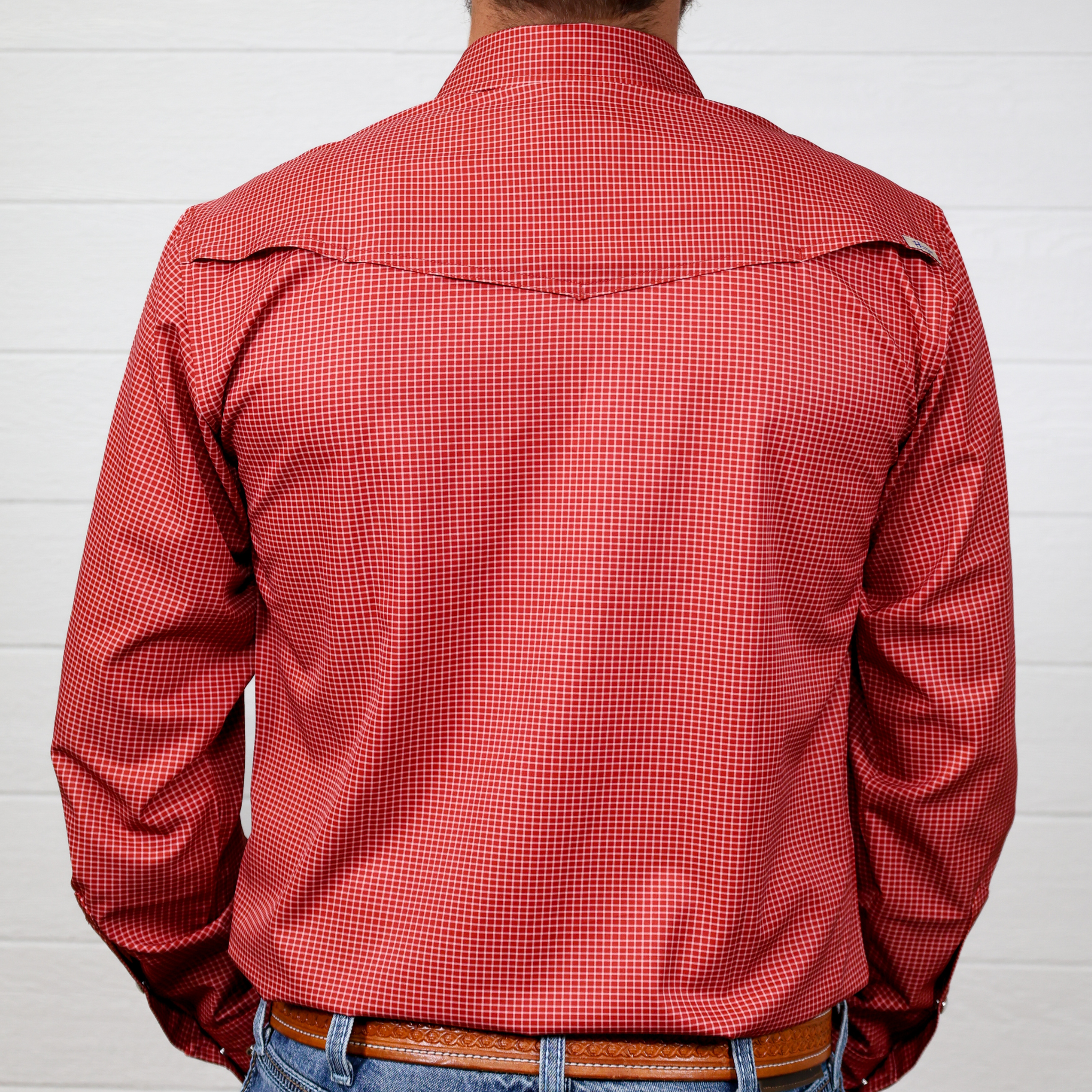 Red checkered shirt worn by a person against a white background. back facing.