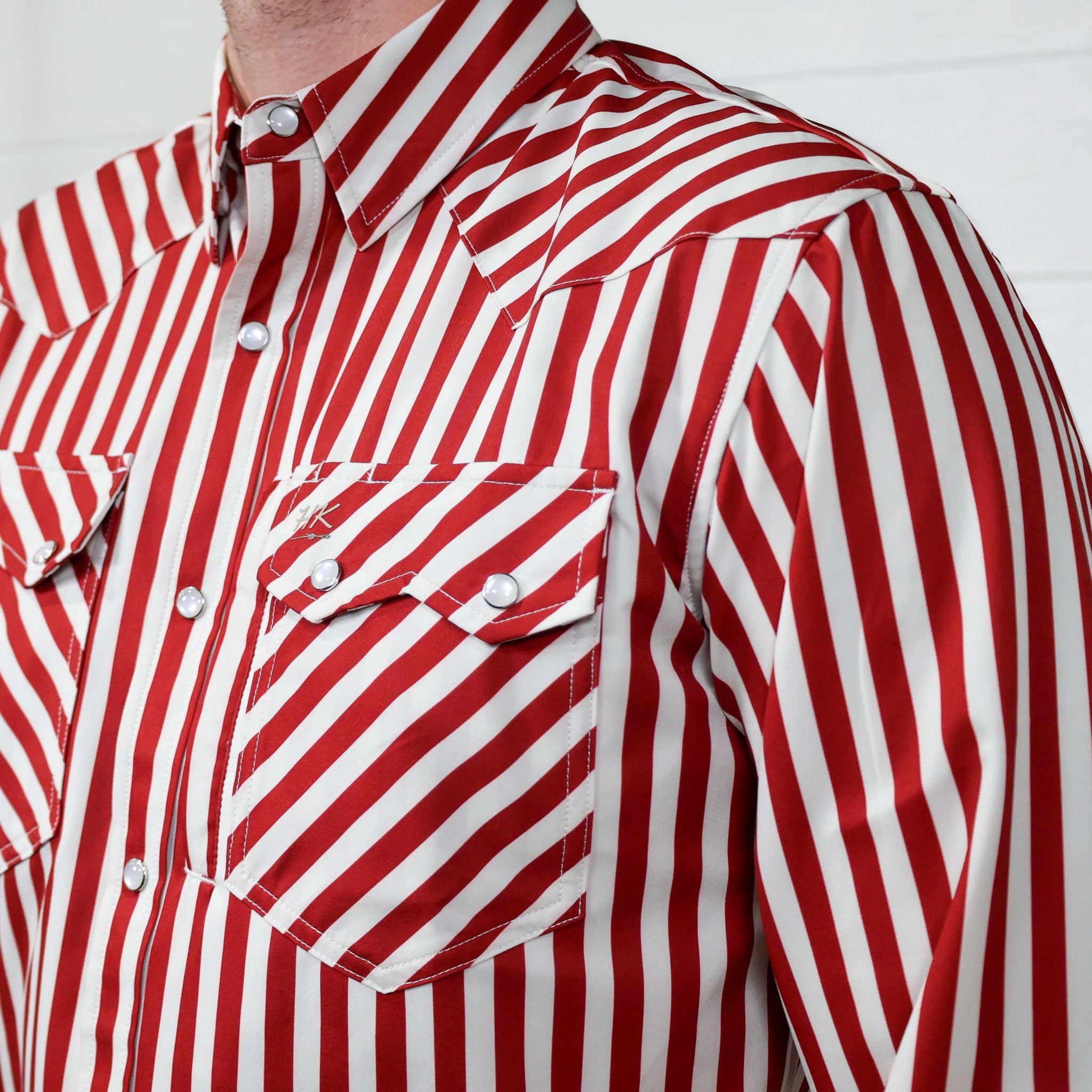 Red and white striped shirt with a sawtooth pocket on a plain background