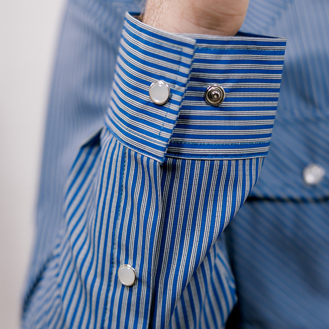 Close-up of a blue and white striped shirt with buttons on a plain background