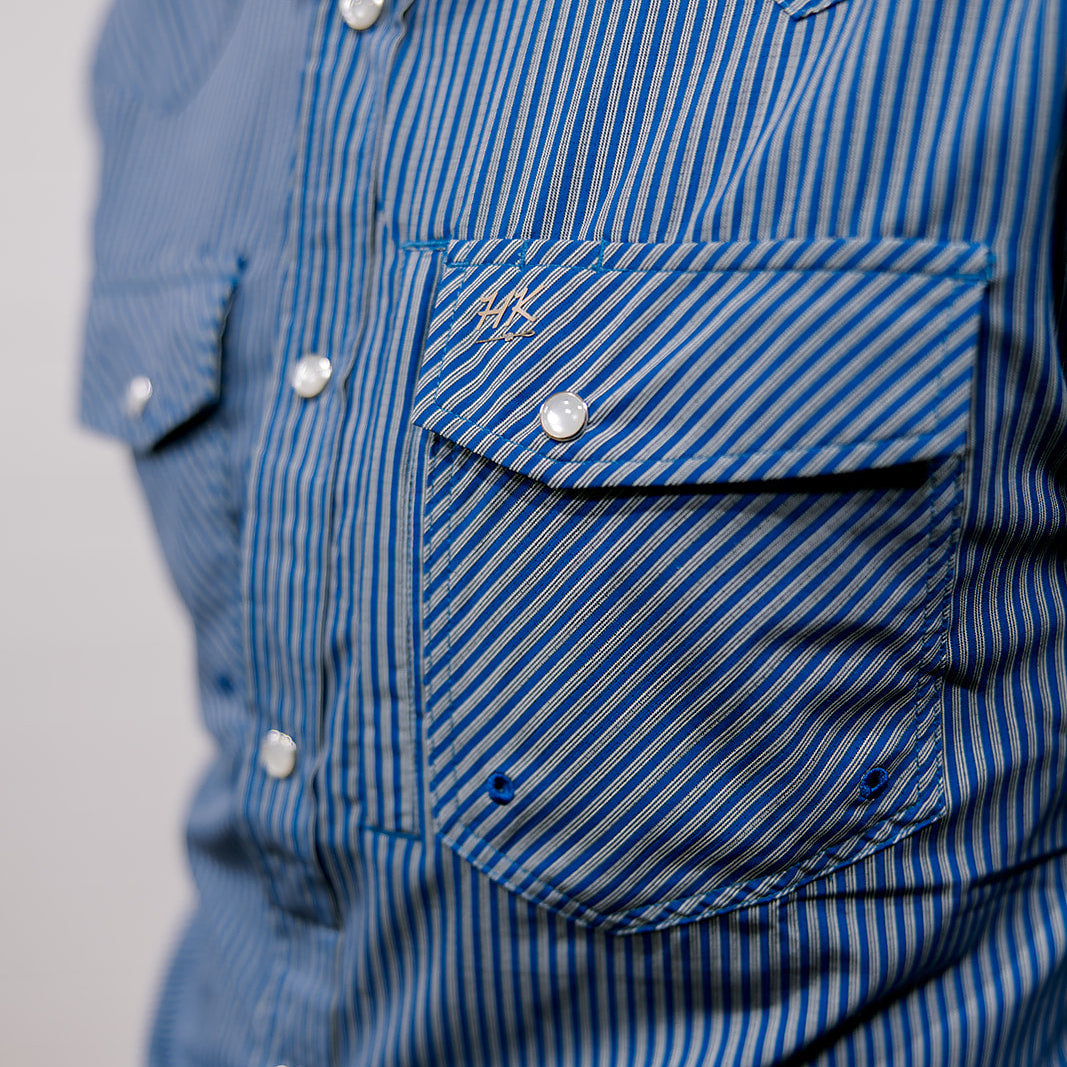 Close-up of a blue striped shirt with a pocket on a plain background