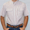 A man wearing a short-sleeve western-style button-up shirt with vertical red and white stripes, paired with blue jeans and a brown leather belt, standing against a white paneled wall.