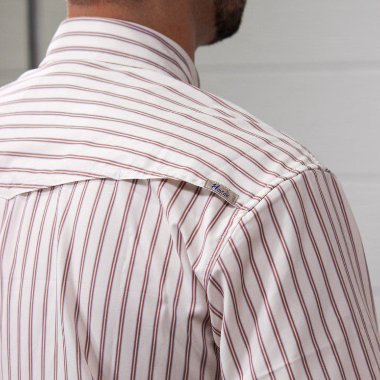 Close-up back view of a man wearing a short-sleeve button-down shirt with thin vertical red stripes on a white base.