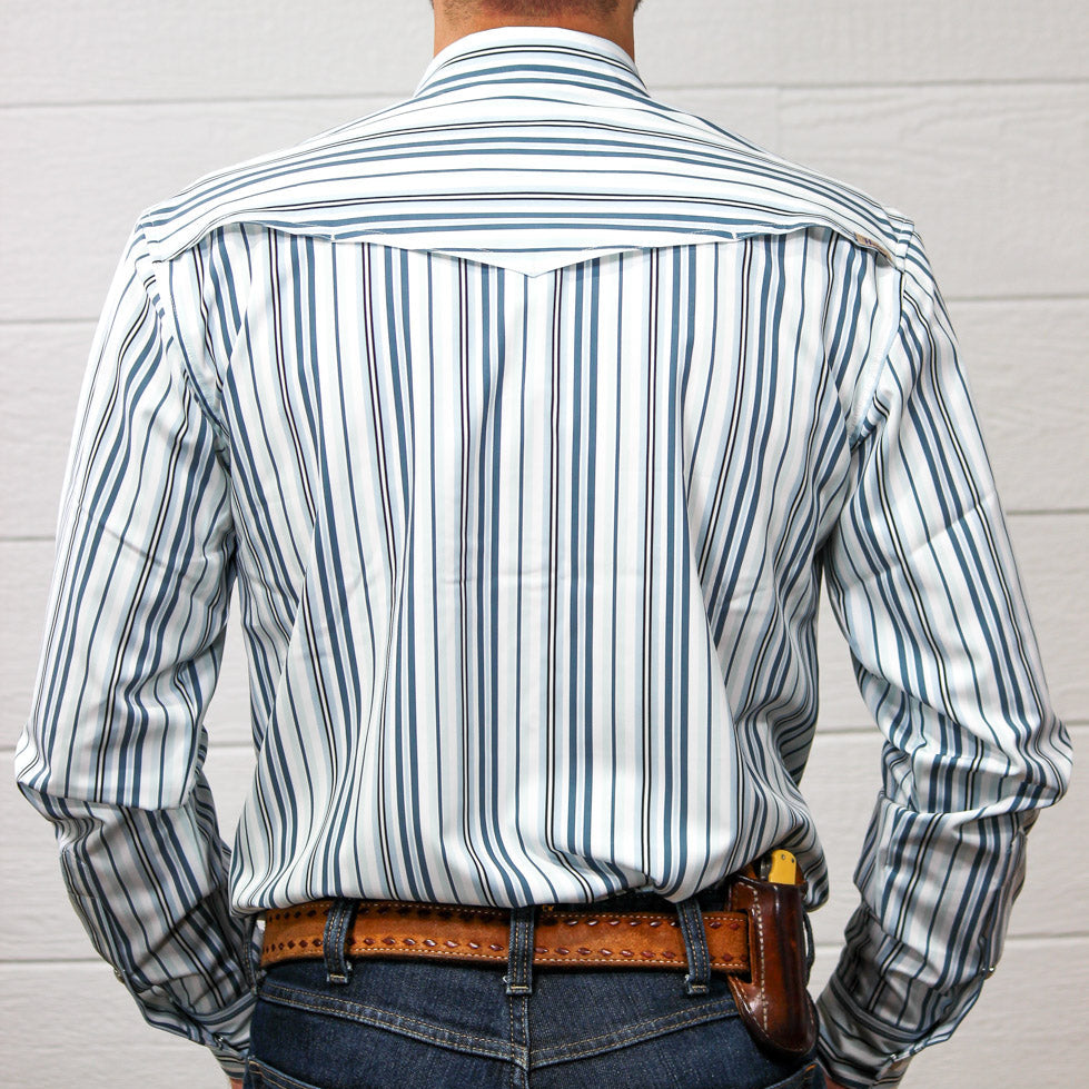 Back view of a man wearing a white long-sleeve button-down shirt with vertical navy blue stripes, tucked into blue jeans with a brown leather belt.