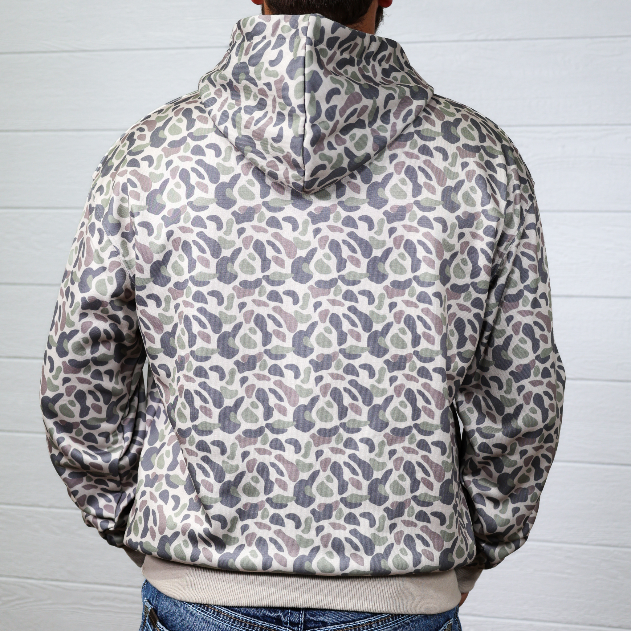 Person wearing a patterned hoodie with a white background showing the back 