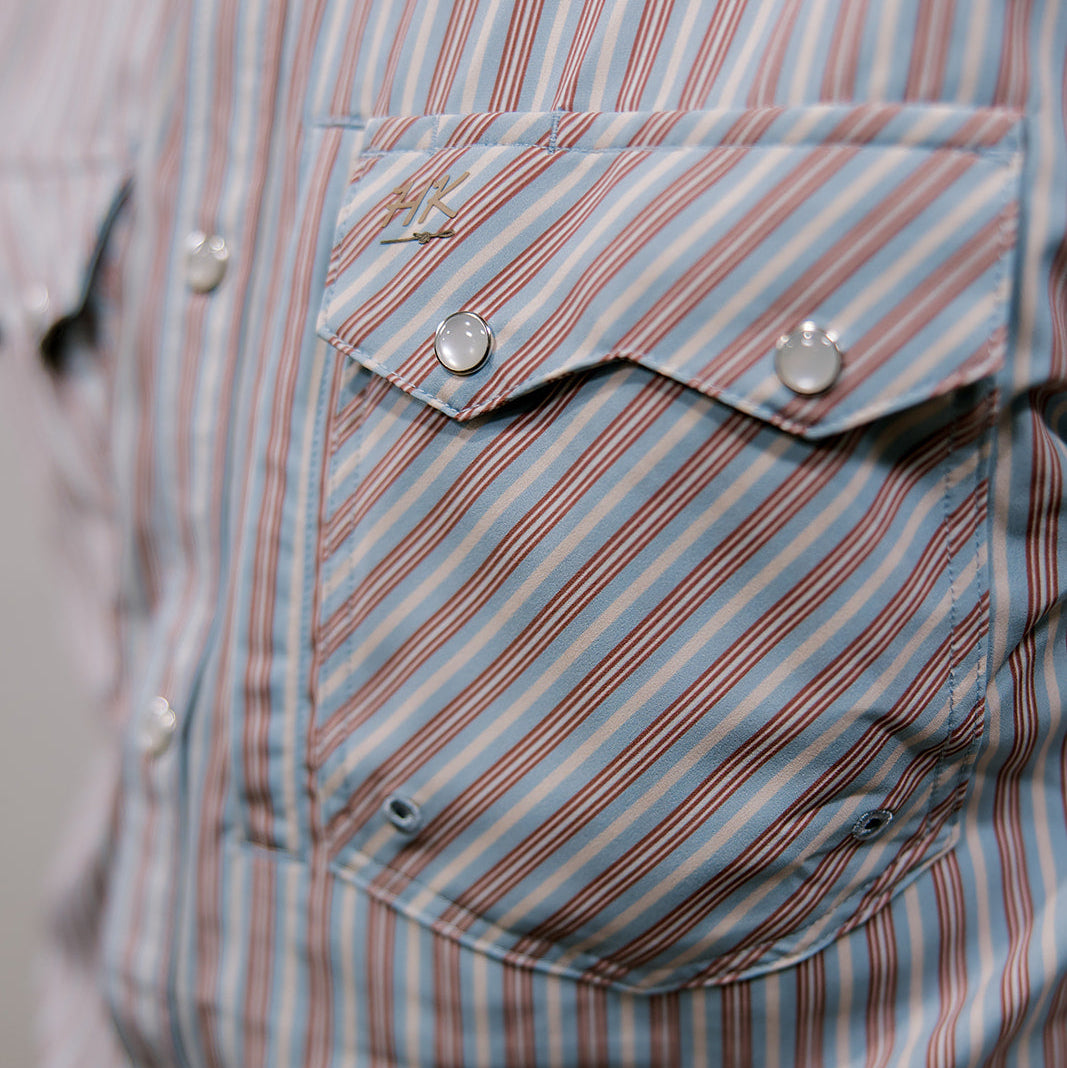 Close-up of a striped shirt with a pocket and buttons.