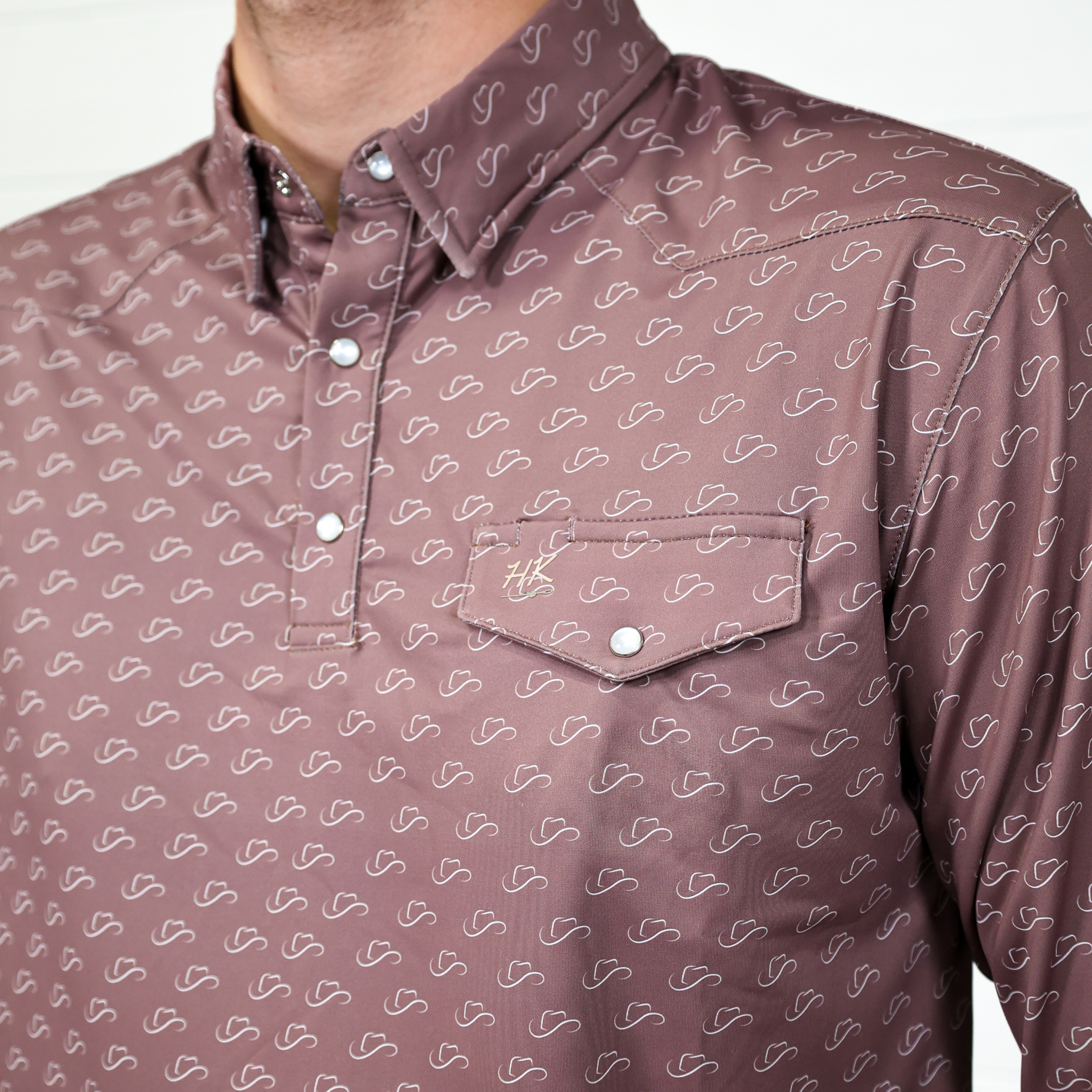 Brown shirt with white pattern and a pocket on a plain background