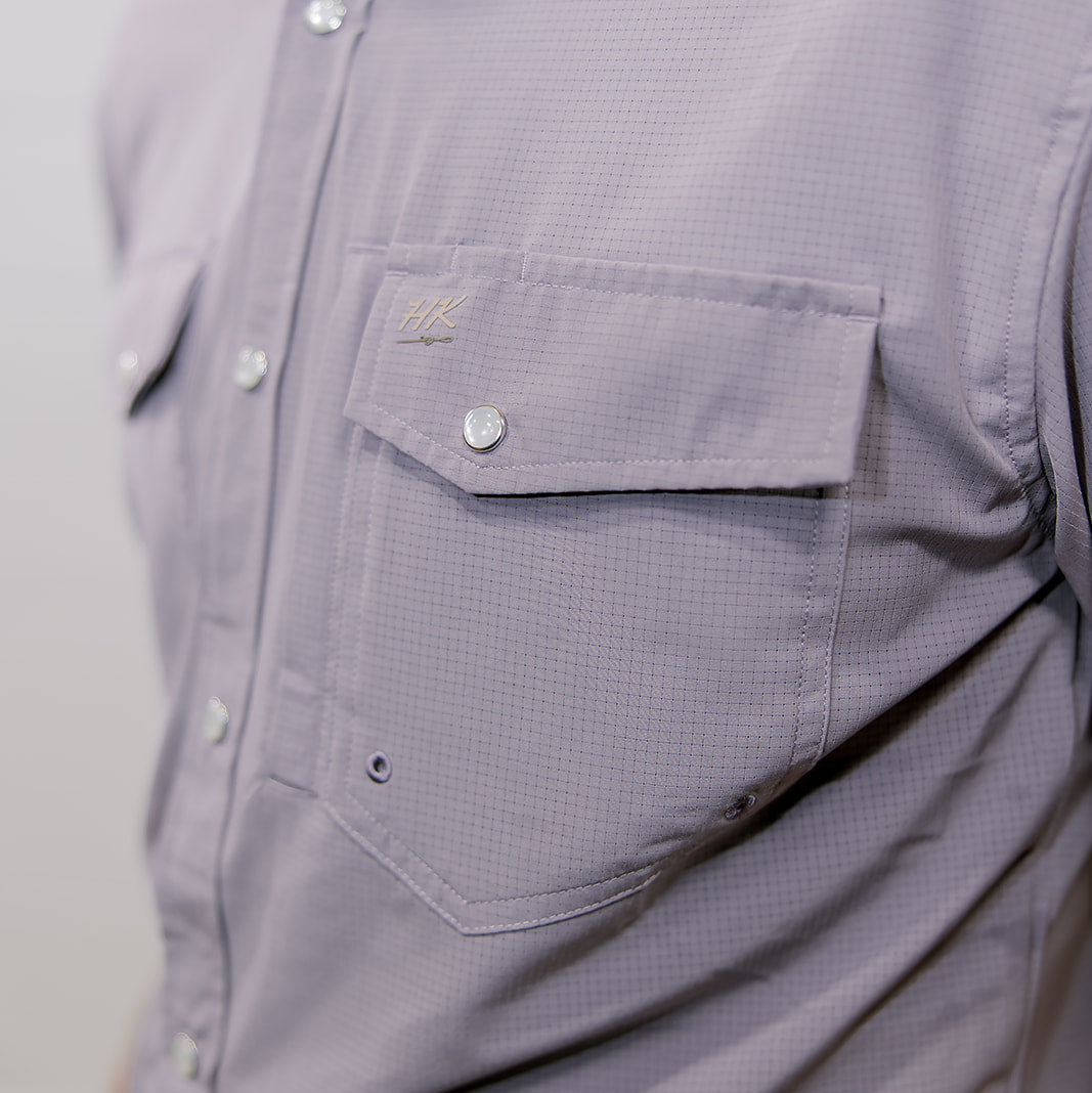 Close-up of a light purple button-up shirt with a pocket on a plain background