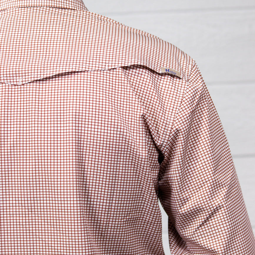 Close-up back view of a person wearing a long-sleeve button-down shirt with a fine red and white gingham check pattern, set against a light gray paneled wall.