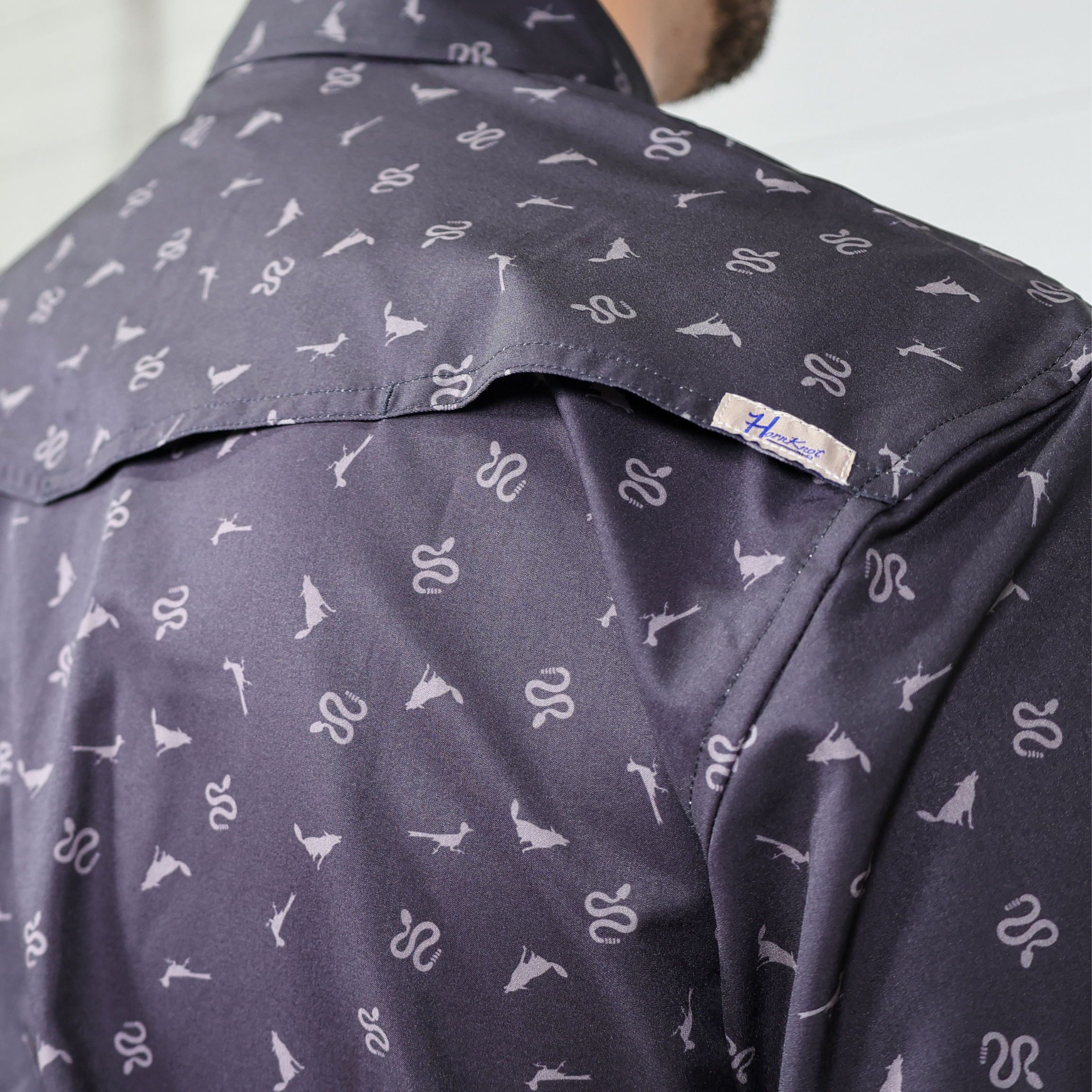 Black shirt with a pattern showing the back vent and back label 