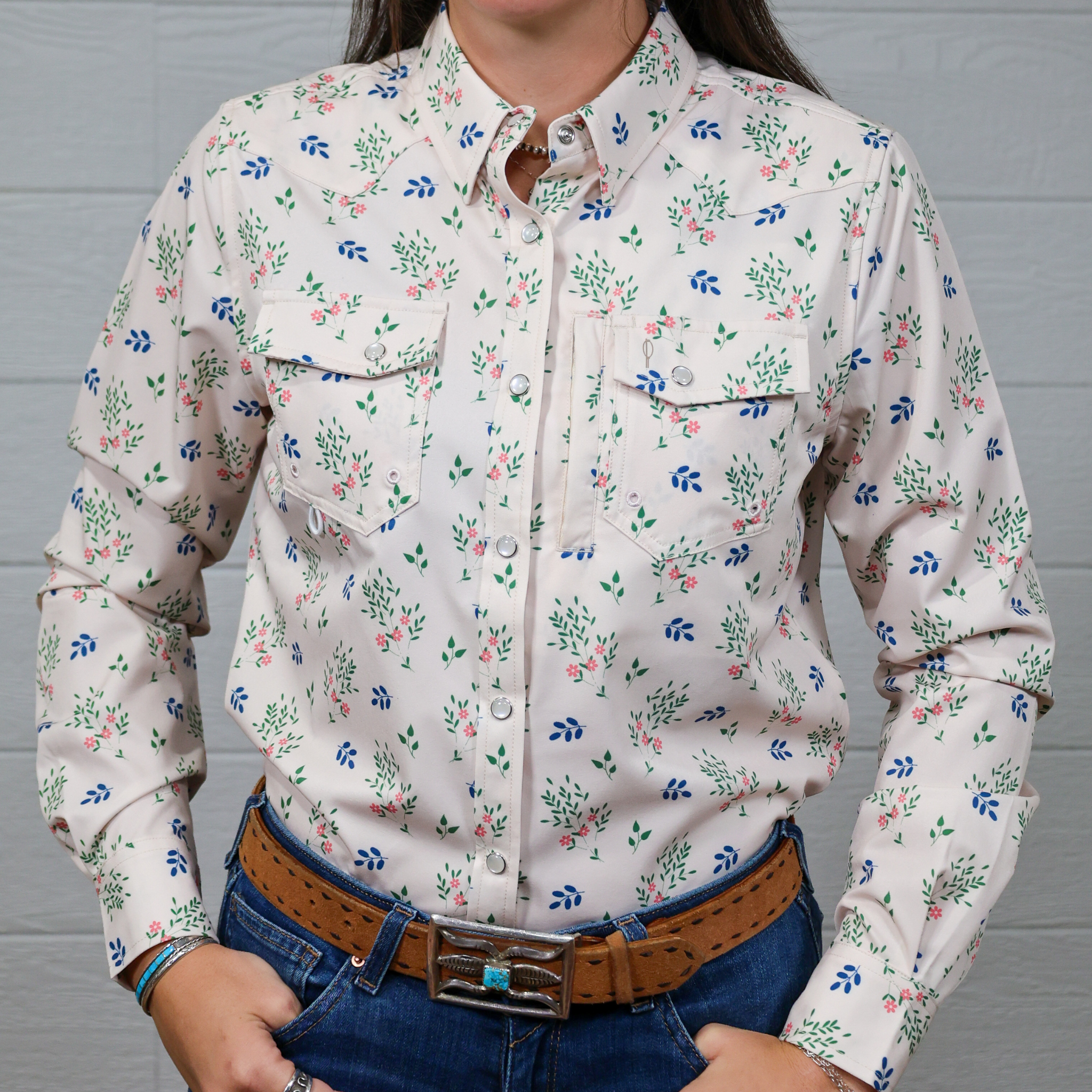 Person wearing a floral patterned shirt with a White background. Forward Facing