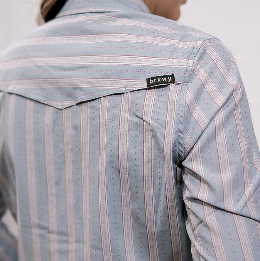 Person wearing a striped shirt with a visible brand label 'brkwy' on a plain background and showing the back vent 