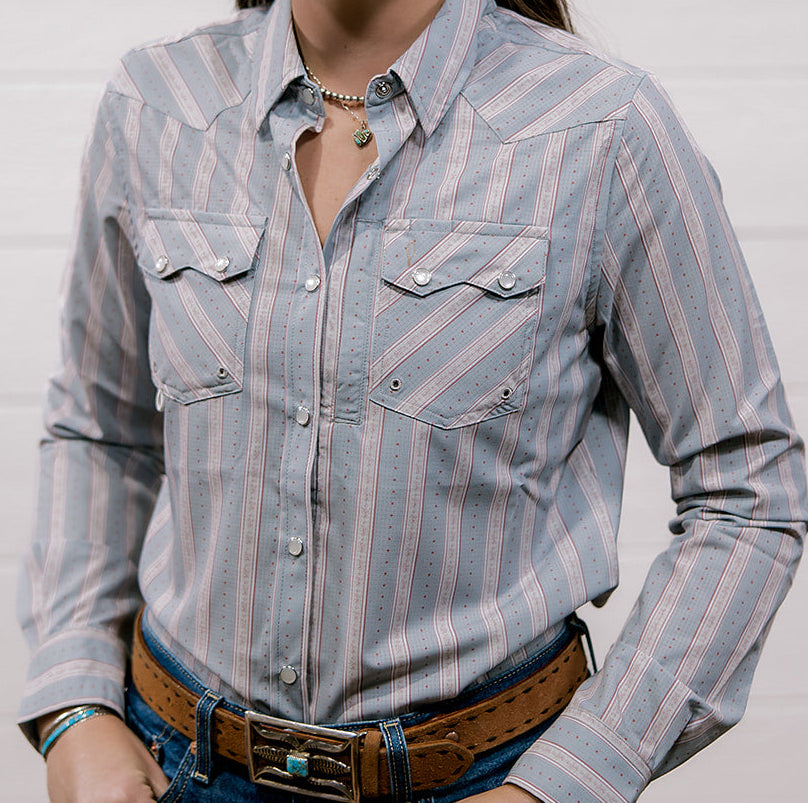 Woman wearing a rangevent striped shirt and jeans against a plain background showing the front