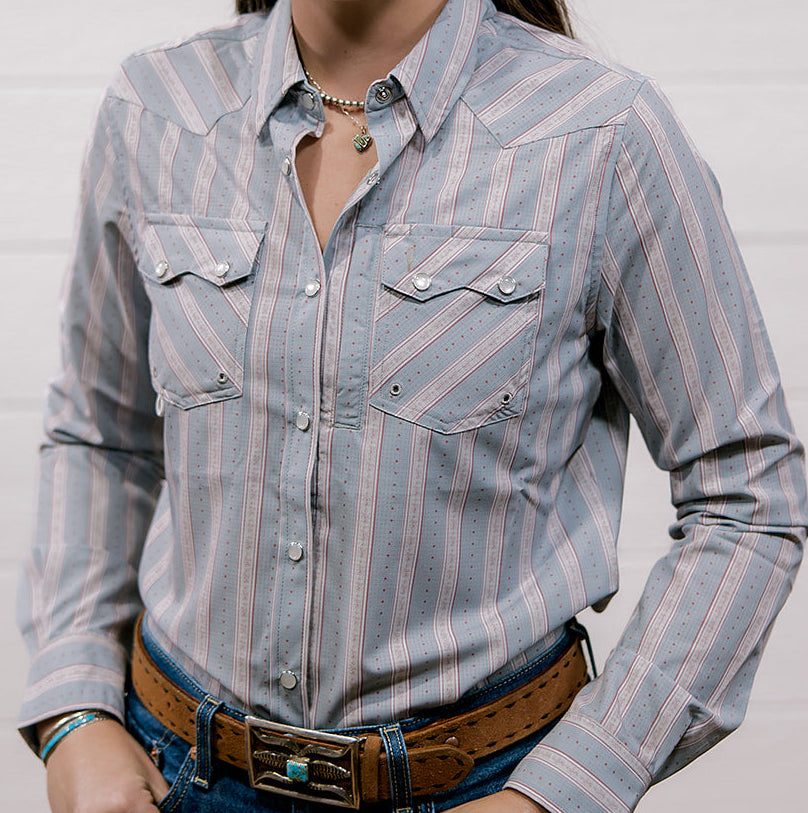 Woman wearing a rangevent striped shirt and jeans against a plain background showing the front