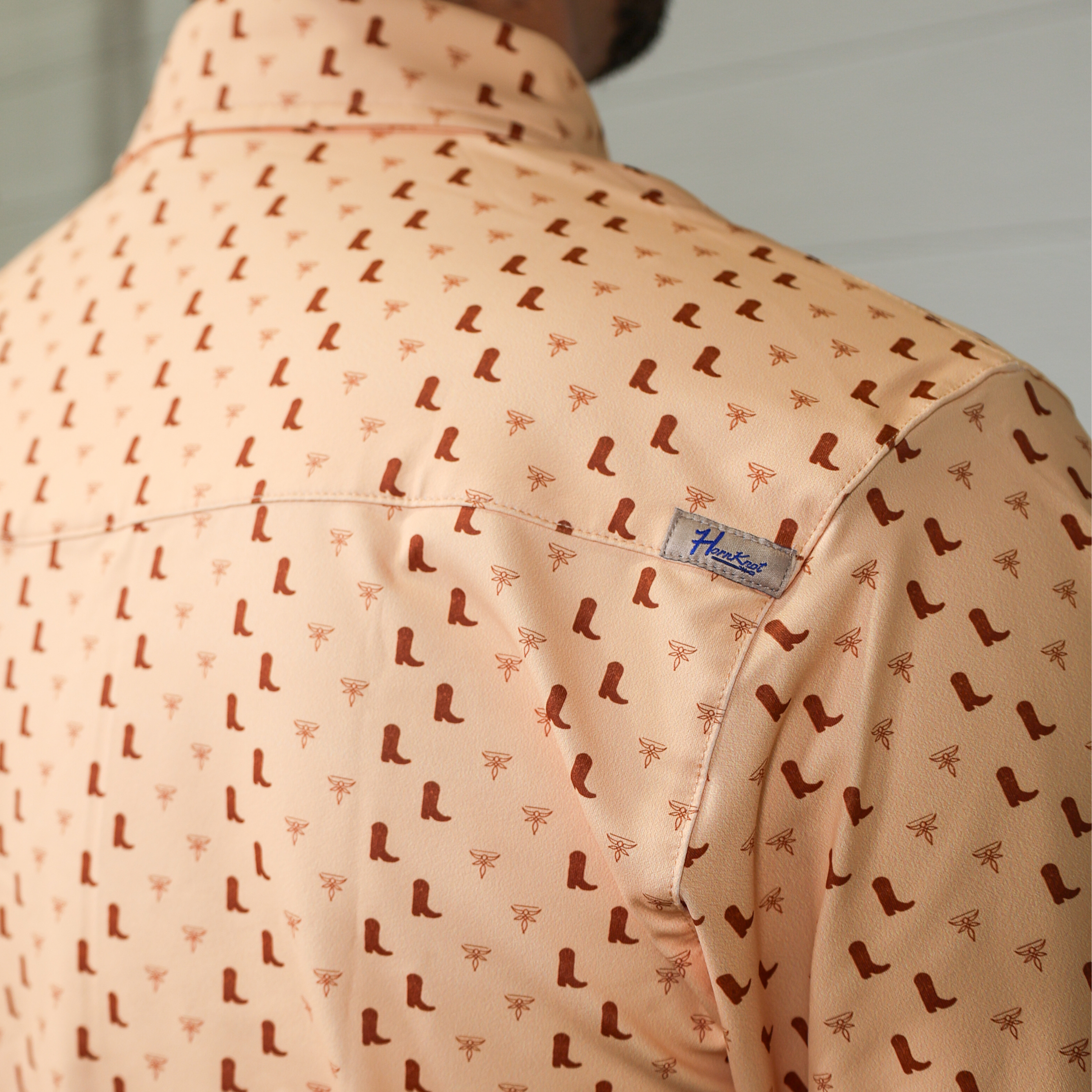 Patterned polo with a visible brand label on the vent.