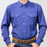 A man wearing a long-sleeve western-style button-down shirt in a medium periwinkle blue color, paired with a brown leather belt and blue jeans, standing against a white wood-paneled wall.