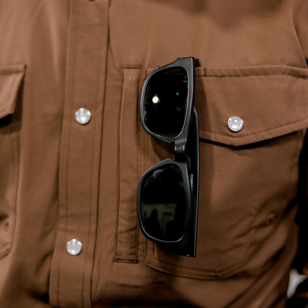 Black sunglasses in a brown shirt pocket