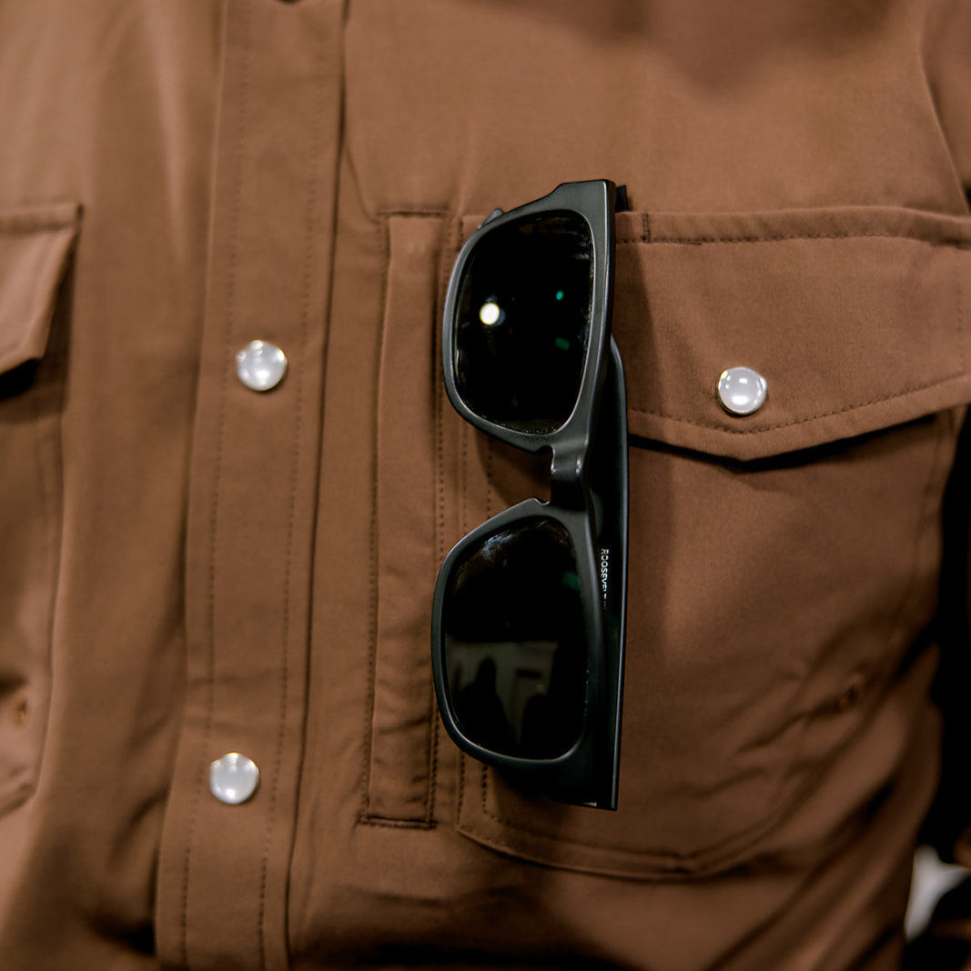 Black sunglasses in a brown shirt pocket