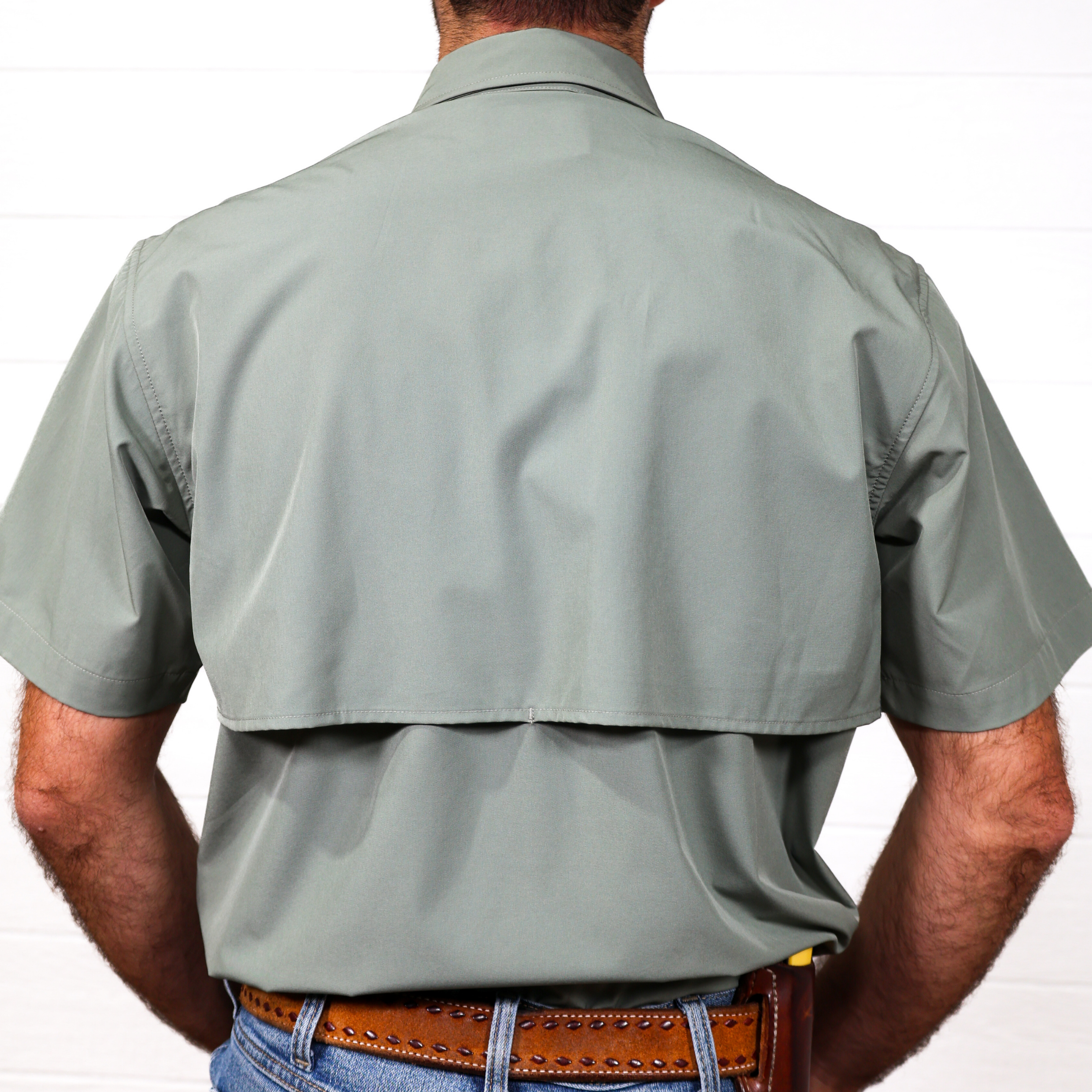 Man wearing a sage short-sleeve shirt on a white background 