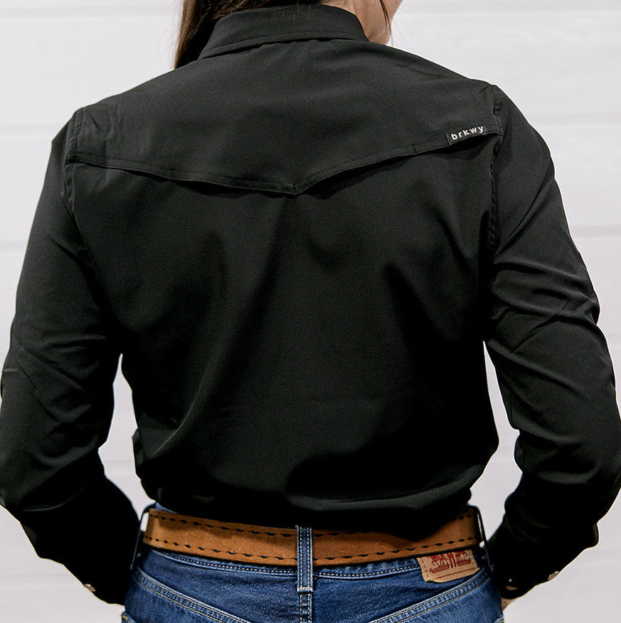 Person wearing a black shirt with a brand logo on a white background. back facing.