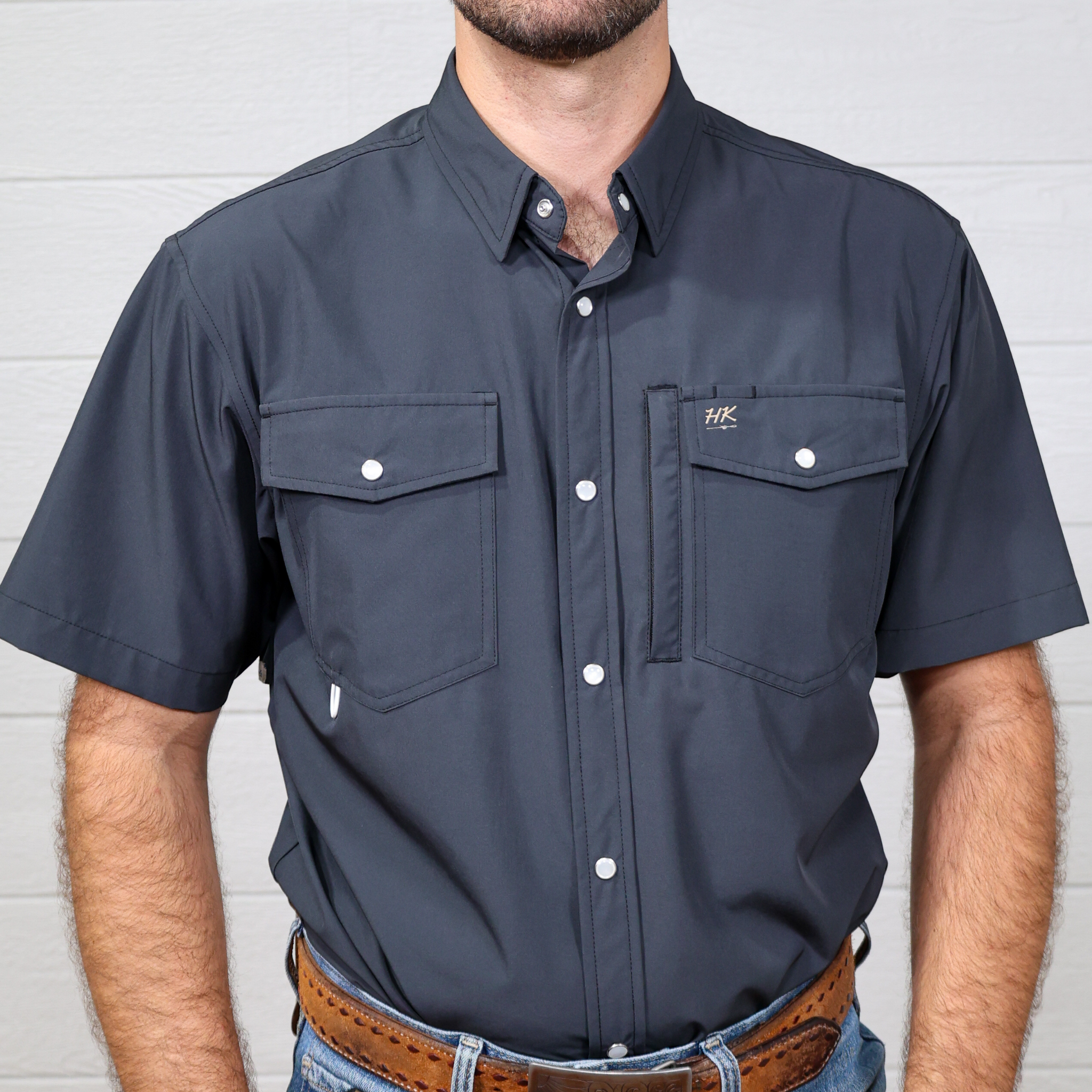 Charcoal short-sleeve shirt with pockets worn by a person against a white background