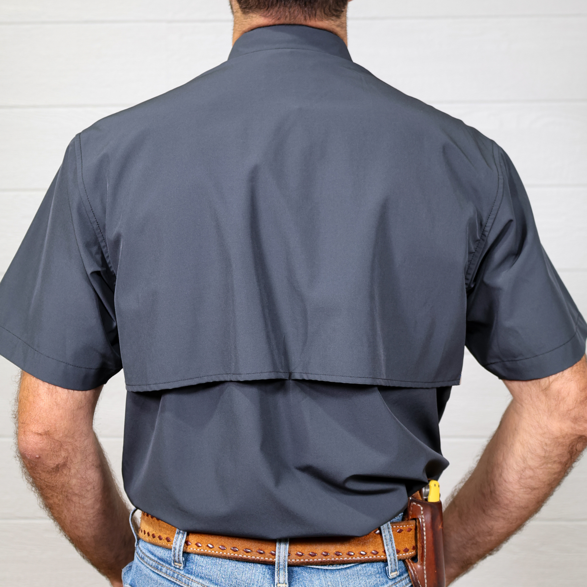 Person wearing charcoal shirt with a white background