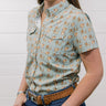 Woman wearing a western patterned shirt and jeans against a white background showing the front