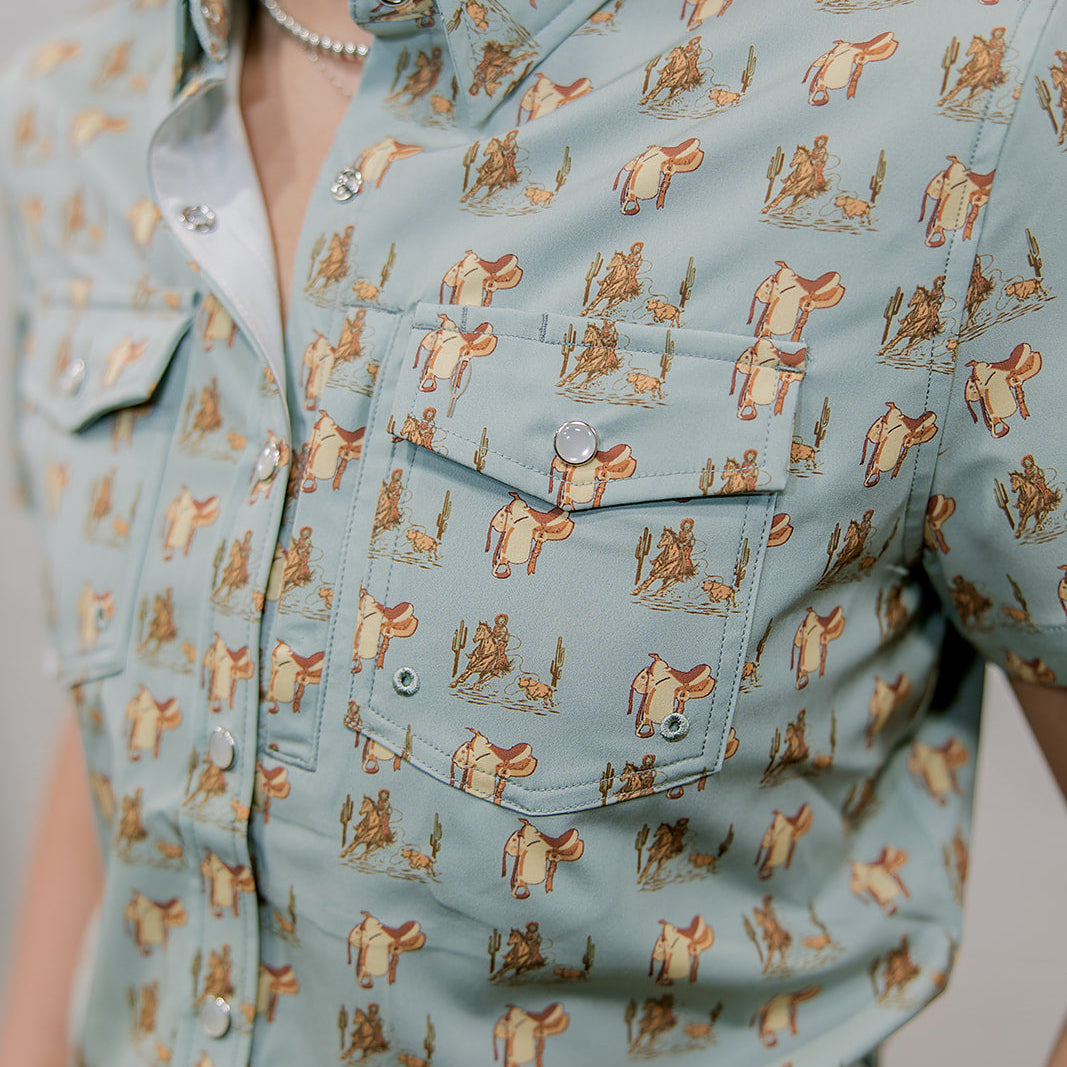 Person wearing a light blue shirt with a western pattern showing the pocket 
