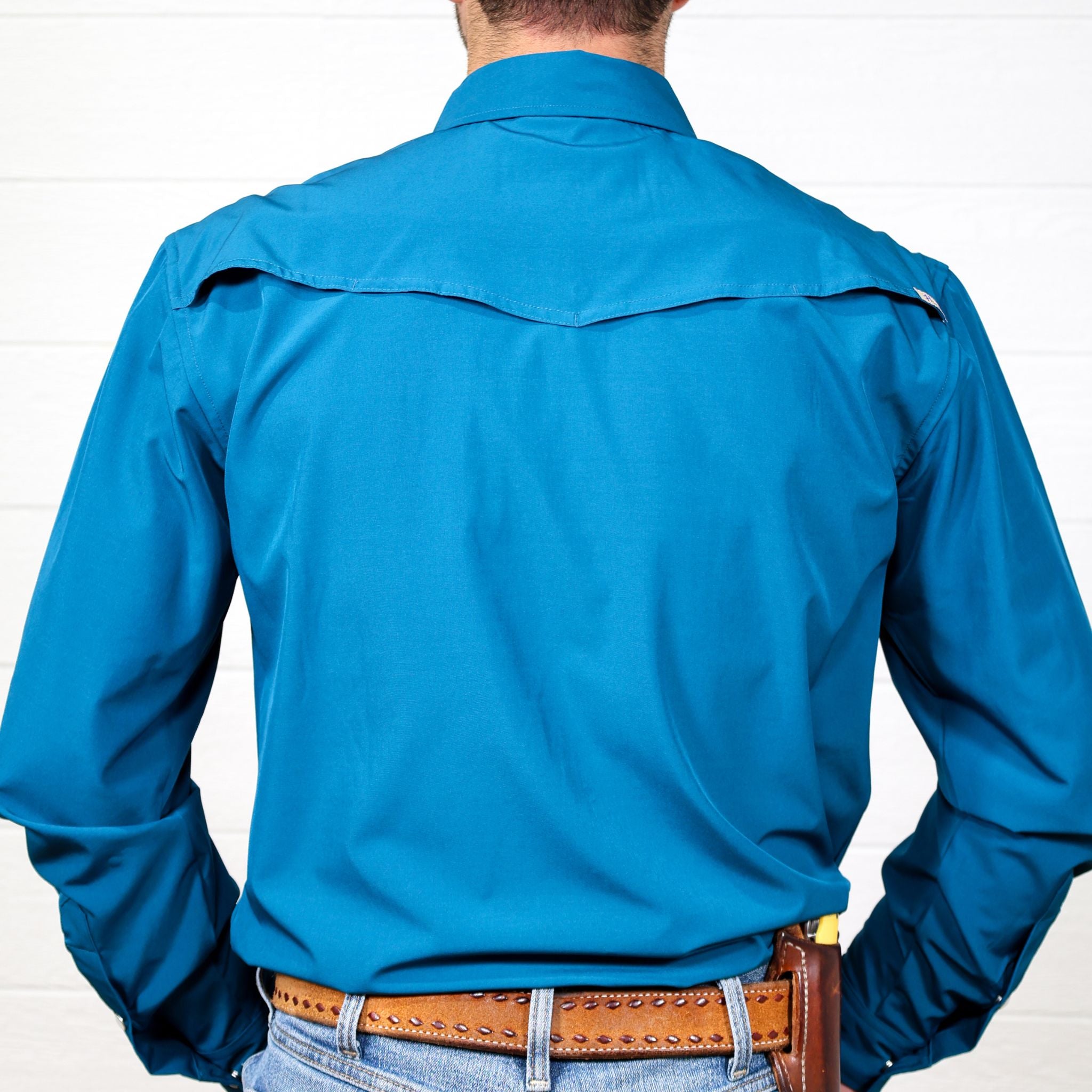 Person wearing a blue shirt with a white background showing the back