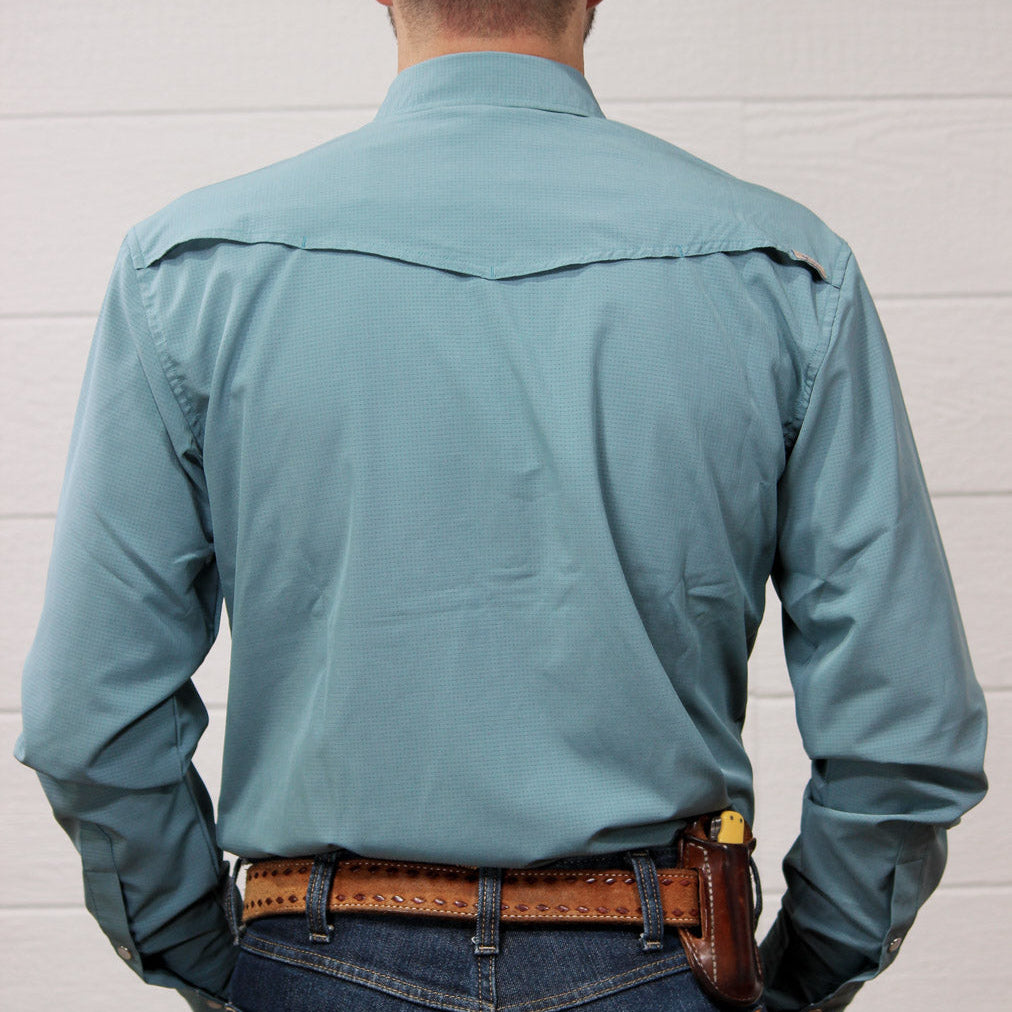 Rear view of a man wearing a light blue-green long-sleeve western shirt tucked into blue jeans with a brown leather belt and holster.