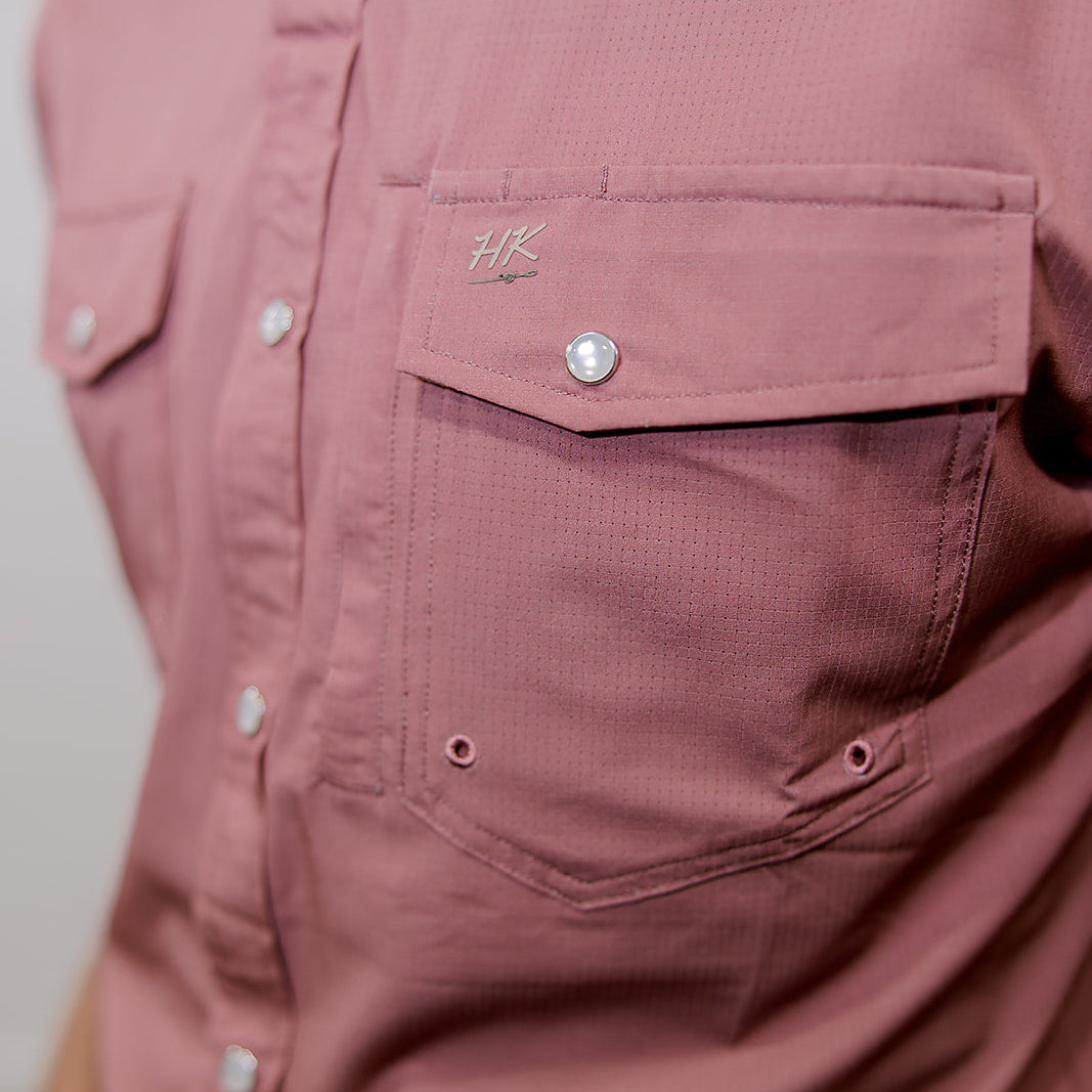 Close-up of a mauve rangevent button-up shirt with a brand logo on the chest pocket.