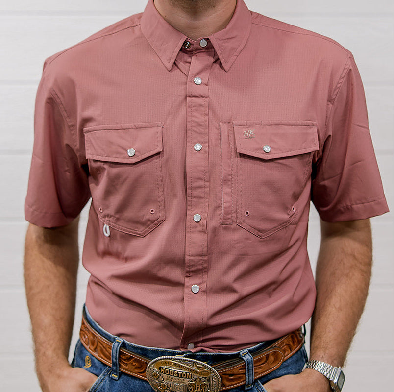 Man wearing a mauve short shirt and blue jeans with a belt buckle against a white background showing the front