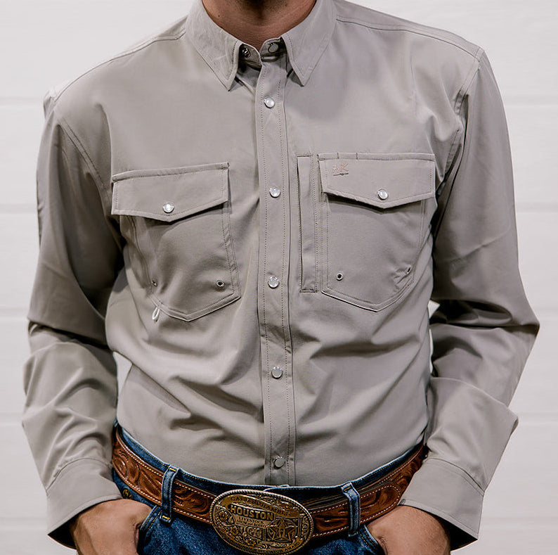 Man wearing a light gray shirt and blue jeans with a belt against a white background. front facing
