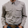 Man wearing a light gray shirt and blue jeans with a belt against a white background. front facing
