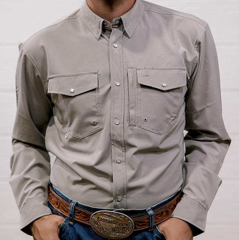Man wearing a light gray shirt and blue jeans with a belt against a white background. front facing
