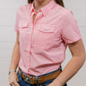 Woman wearing a pink checkered shirt and blue jeans against a plain background. front facing.