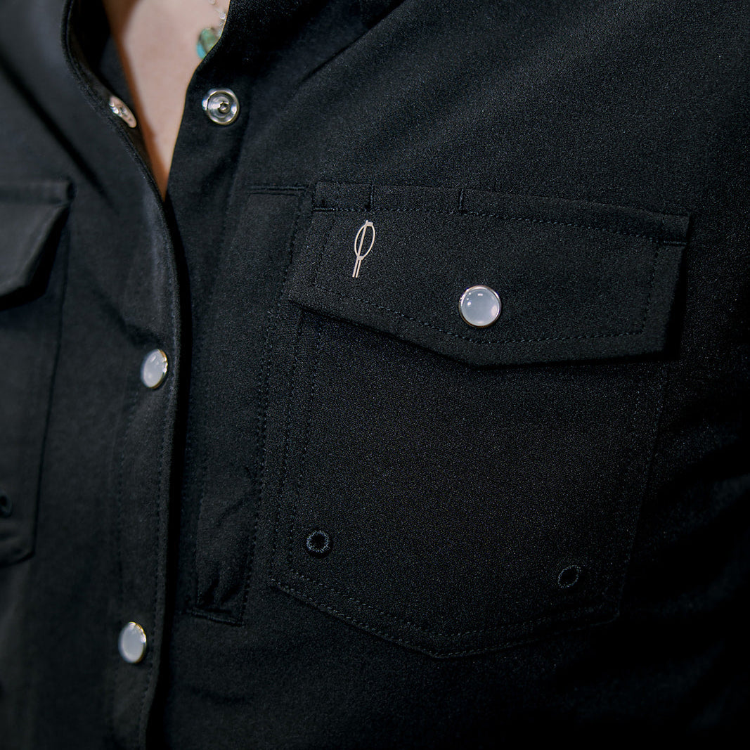 Close-up of a black shirt with buttons and a pocket detail