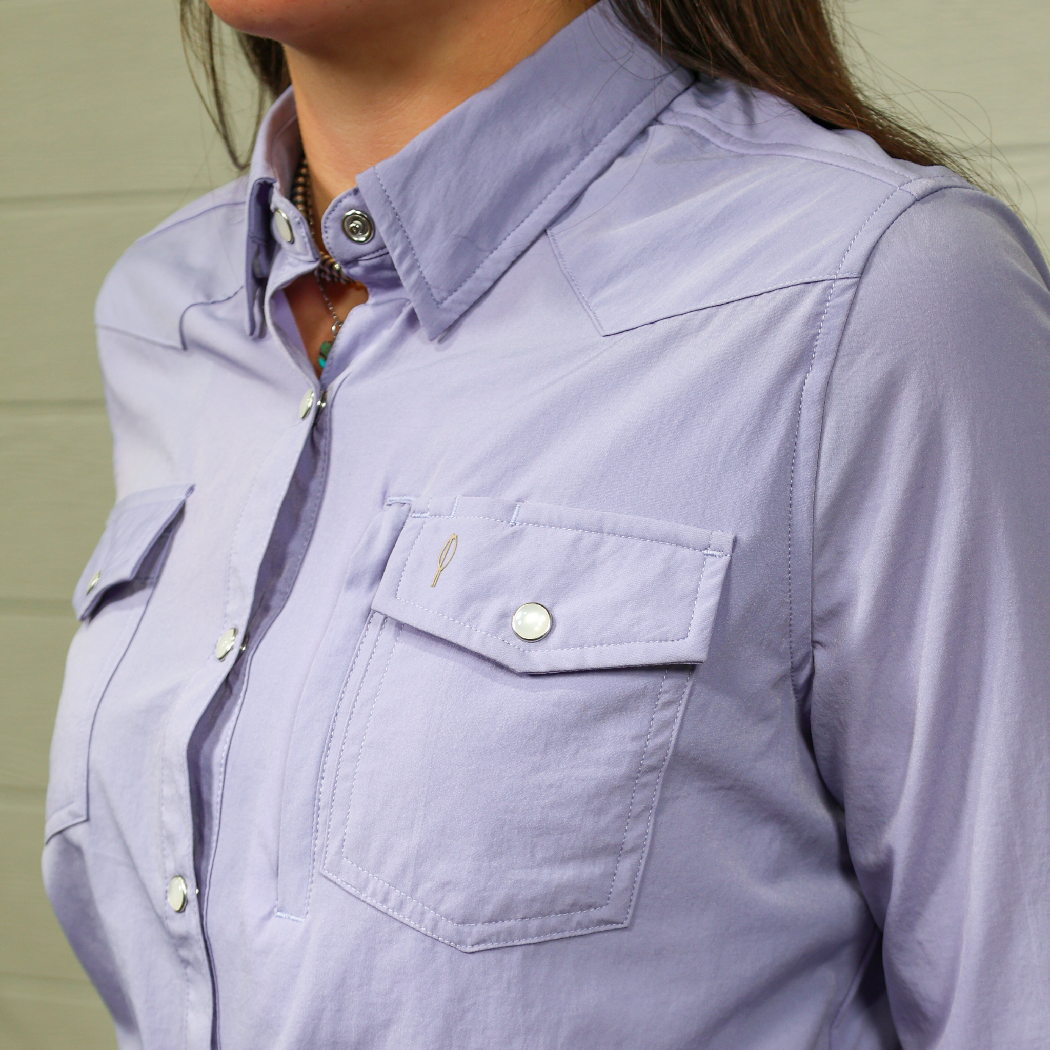 Close-up of a person wearing a light purple shirt with a white background