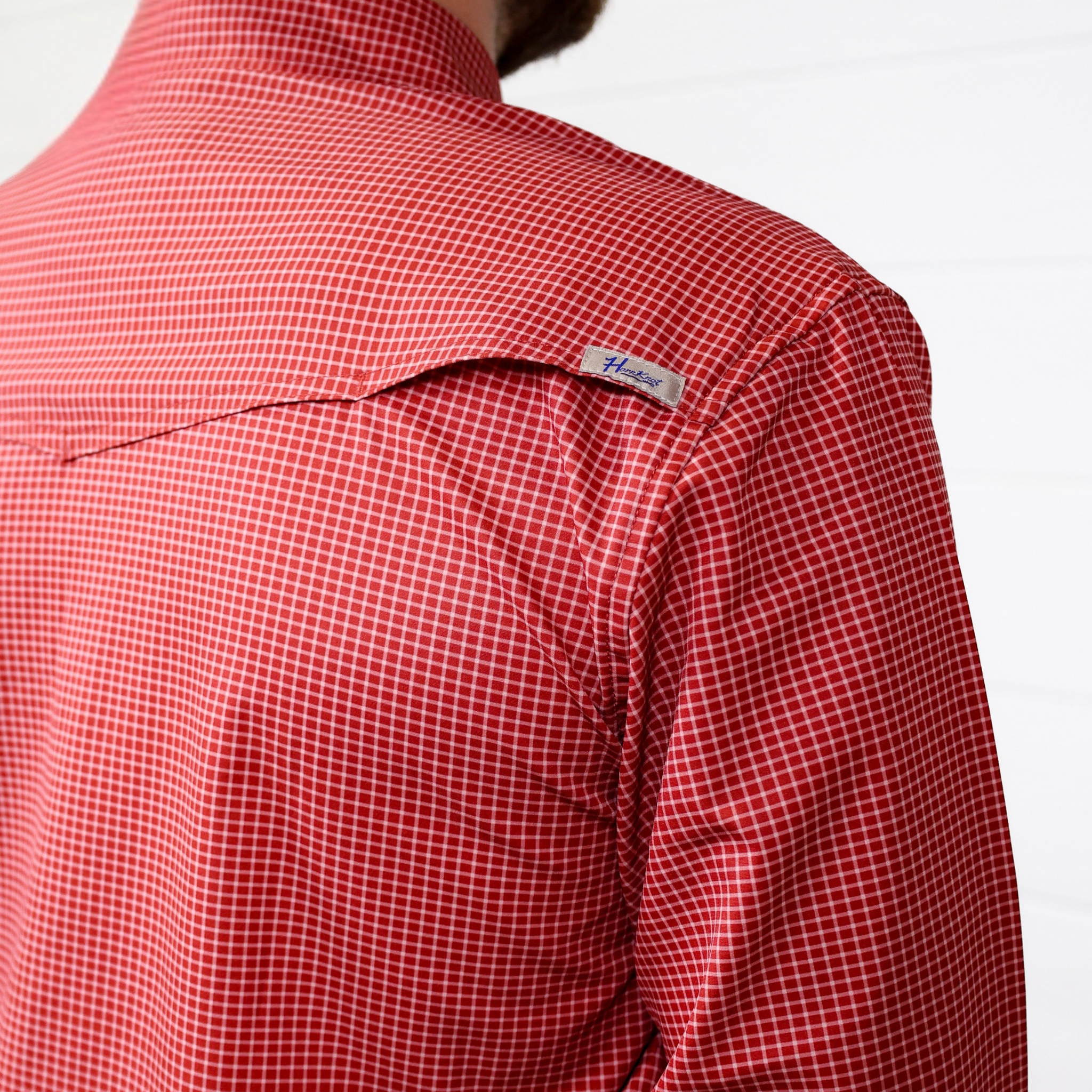Red checkered shirt with a brand label on a white background. back facing. 